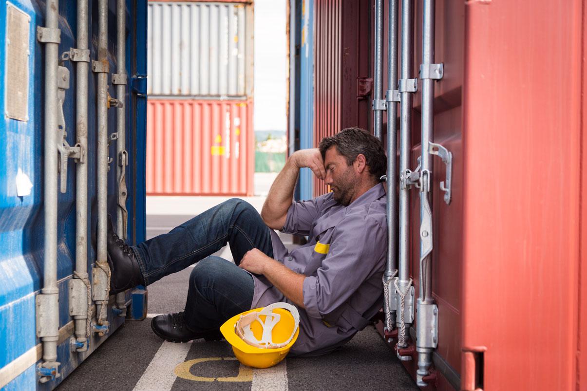 Worker sleeping between two shipping containers